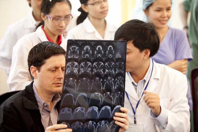 REI volunteer and Vietnamese hospital staff examine an XRay